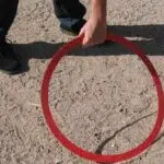 Un joueur pose le cercle au début d'une partie de pétanque